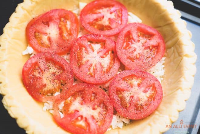 Unbaked pie crust filled with diced onions and topped with crumbed, cooked bacon