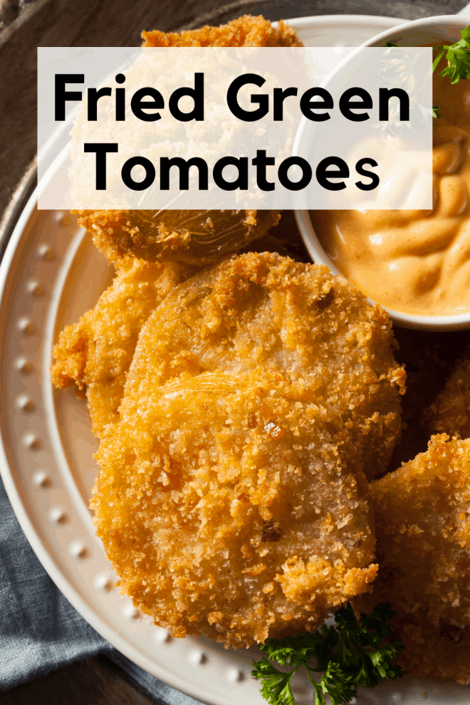 Fried Green Tomatoes on a white plate with a dipping sauce in a bowl on the side