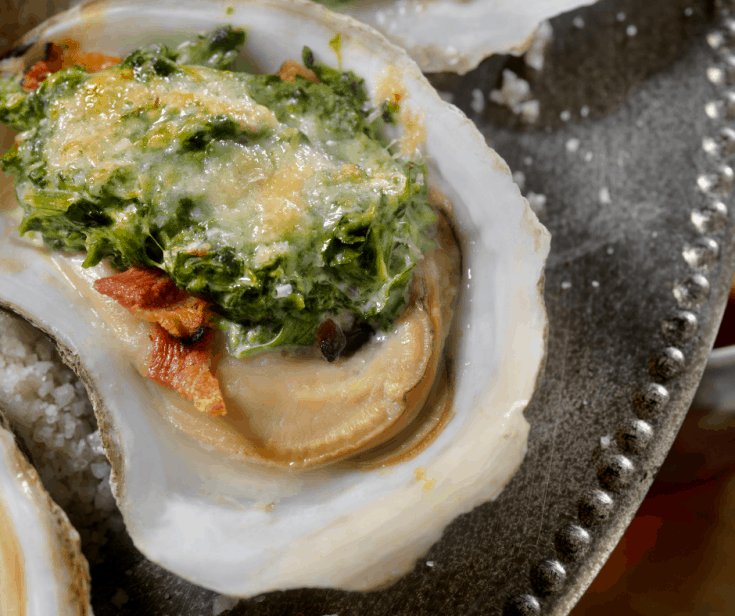 Parmesan Oyster Bake - Oysters on the half shell topped with bacon, cheese and baby spinach leaves