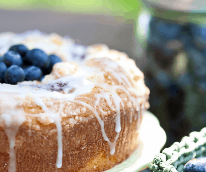 Blueberry Streusel Coffee Cake on white platter topped with fresh blueberries