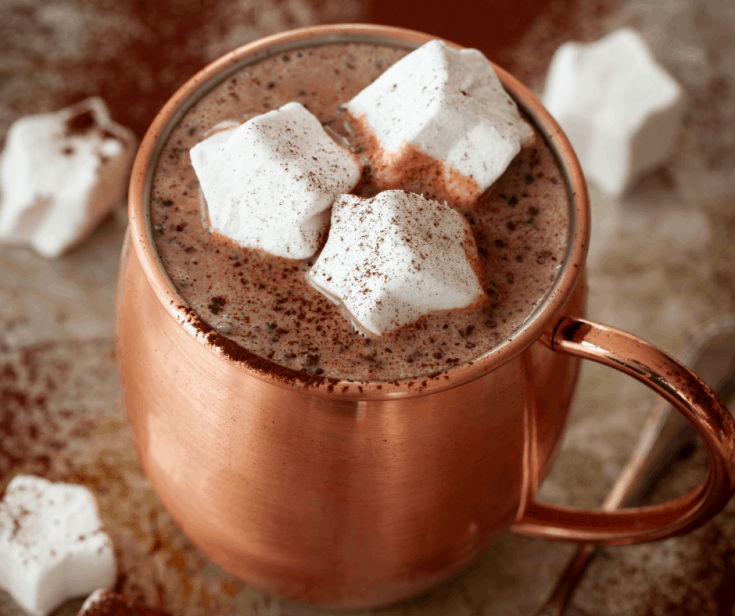 hot chocolate in a copper mug topped with marshmallows