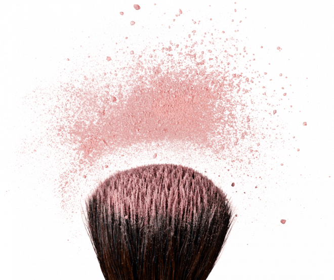 Blush Makeup Tips for Women Over 50 - Large blush brush with blush particles fanning out on white background