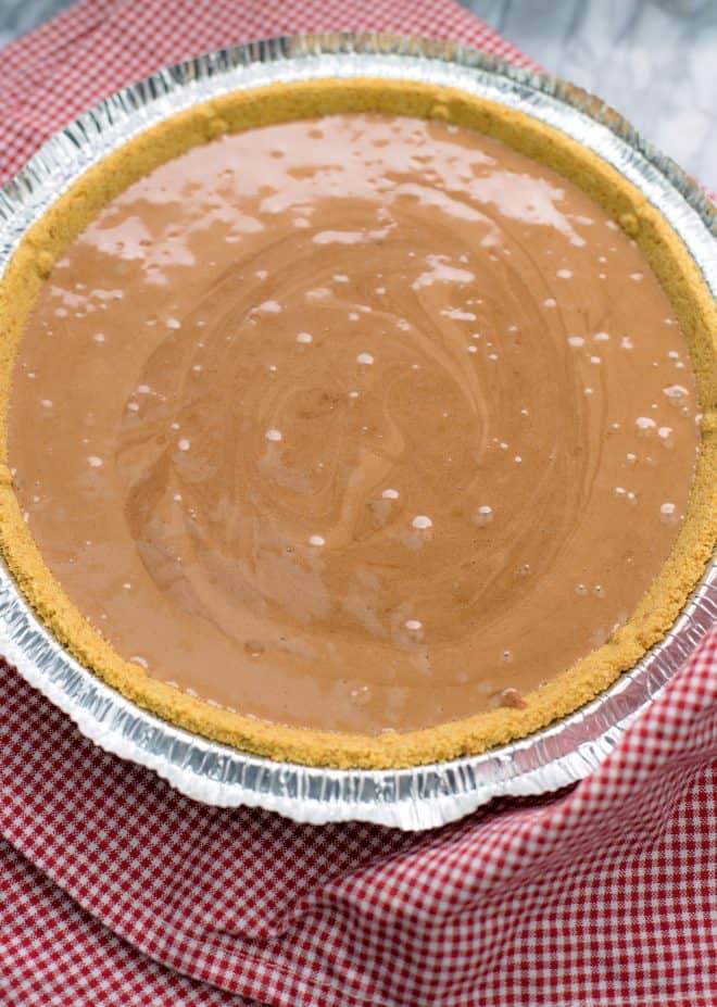 graham cracker crust filled with chocolate pie filling on red napkin