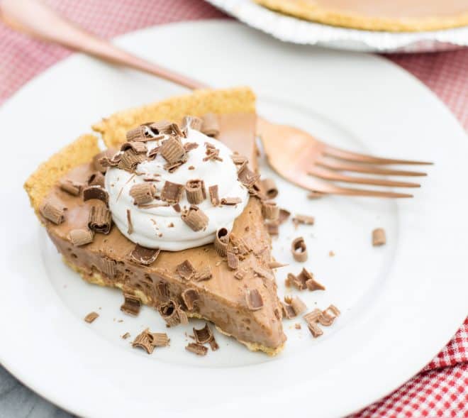 Close Up Photo of Candy Bar Pie on white saucer with fork 