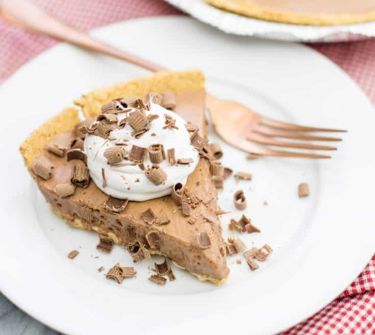 Close Up Photo of Candy Bar Pie on white saucer with fork