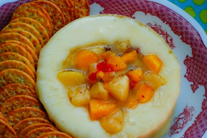 Baked Brie Cheese topped with fresh, diced peaches and hot pepper jelly