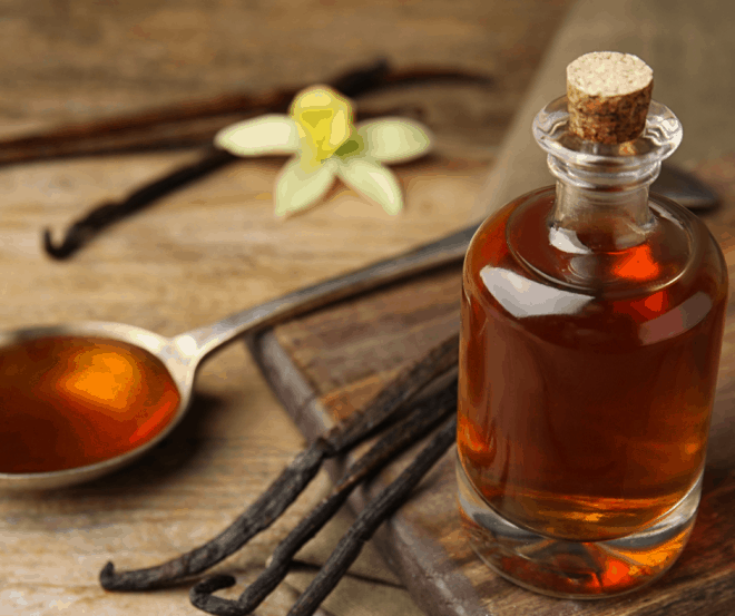 Homemade Vanilla Extract With Vanilla Beans and A tablespoon of vanilla on cutting board