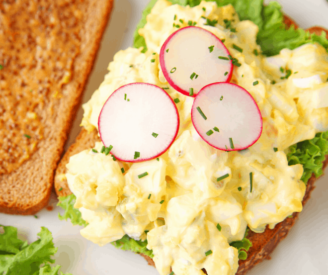 Egg Salad Open Face Sandwich on wheat bread and topped with chives and radishes
