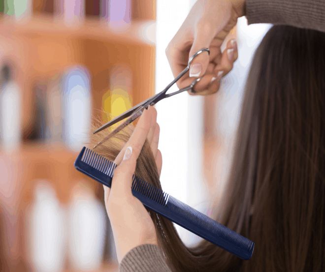 Hairstylist trimming girl's hair