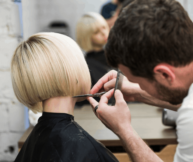 Girl with short blonde hair getting a trim at hairstylist