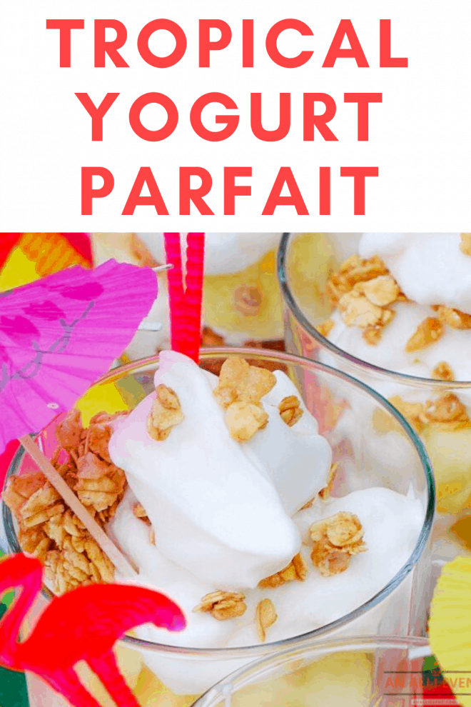 Tropical Yogurt Parfait layered in a clear glass topped with granola and unbrella