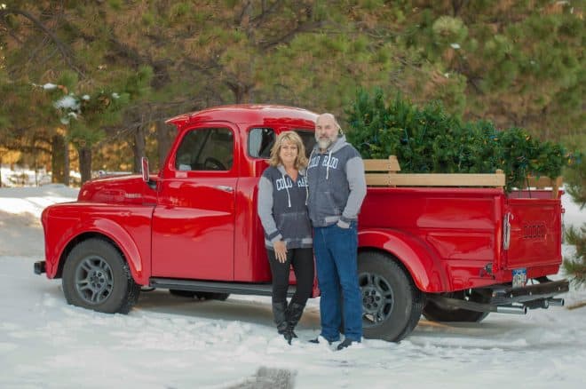 A couple standing in front of a red truck