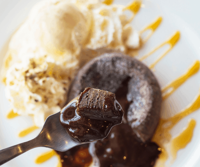 A bite of Mexican Lava Brownies on a white plate served with ice cream