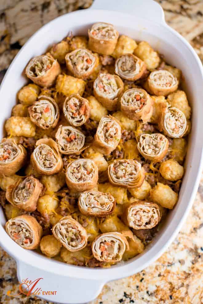 Top Cheesy Egg Roll and Tater Tot Breakfast Bake with remaining cheese and egg roll slices.