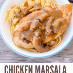 Chicken Marsala over noodles in a white bowl