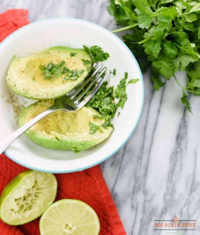 Add lemon juice to avocados and cilantro. Mash with a fork.