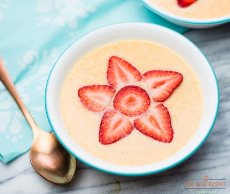 Chilled Cantaloupe Soup in white bowl garnished with a strawberry flower