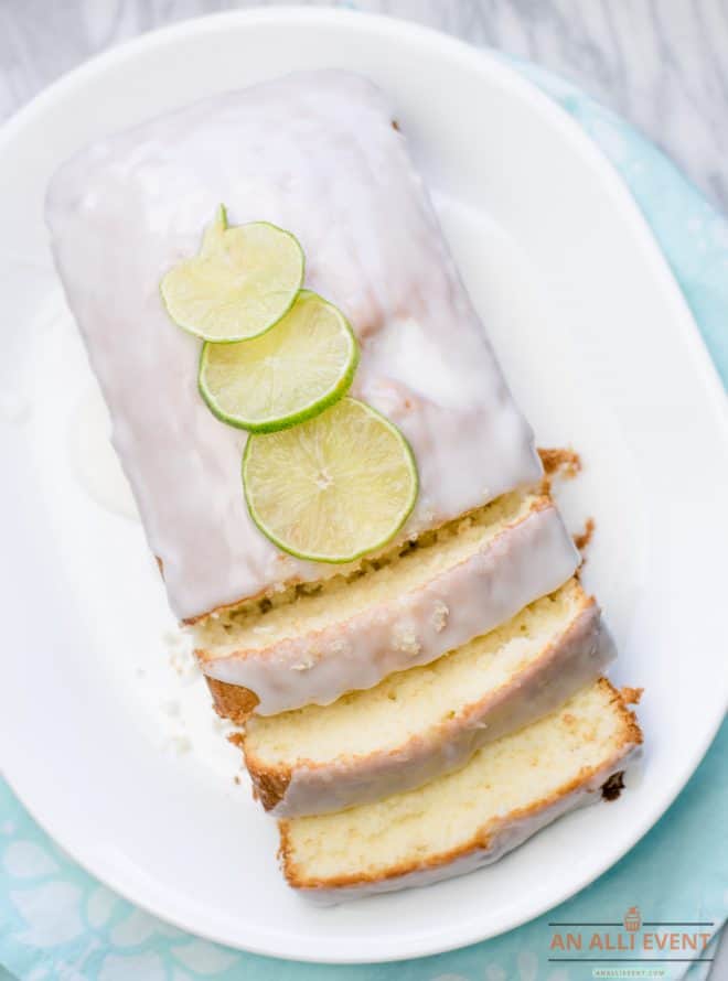 Overhead shot of key lime loaf on white platter and topped with sliced limes