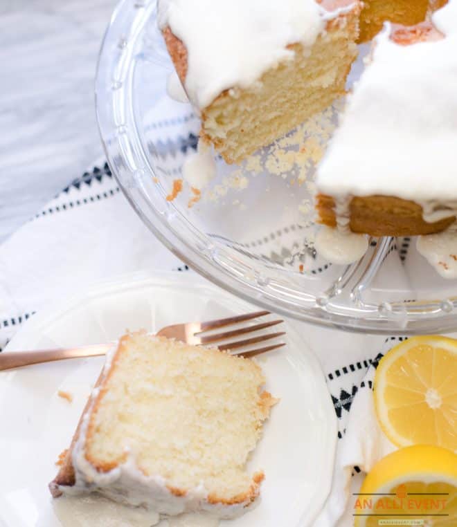 A slice of lemon buttermilk pound cake on white plate with gold fork