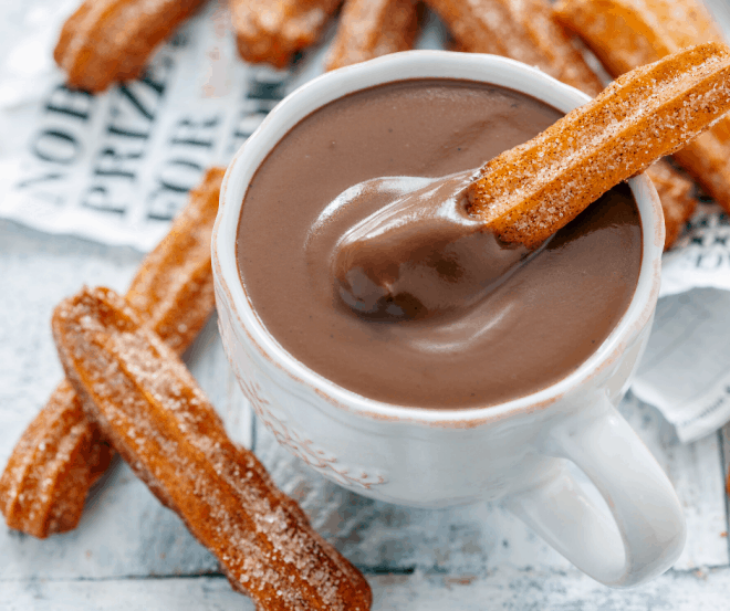 Easy Homemade Churros on a plate, dipped in chocolate