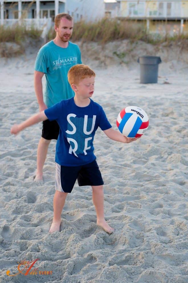 Child playing volleyball on beach