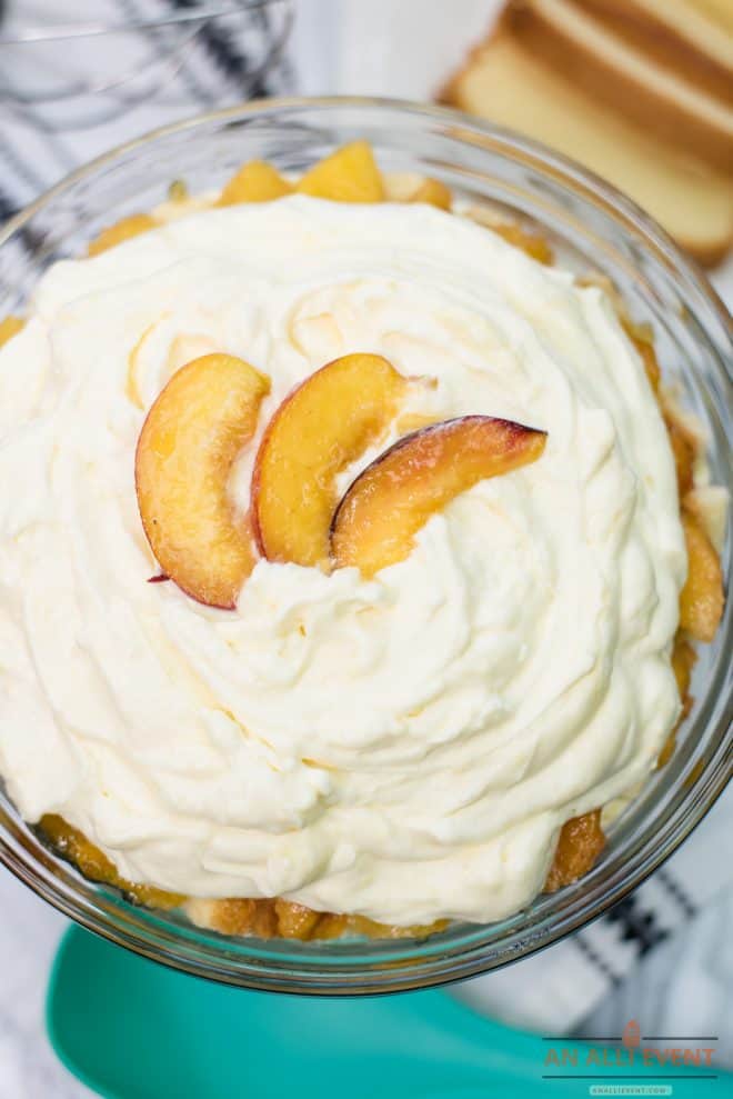 Layered Peaches and Cream Trifle in glass bowl, garnished with sliced peaches