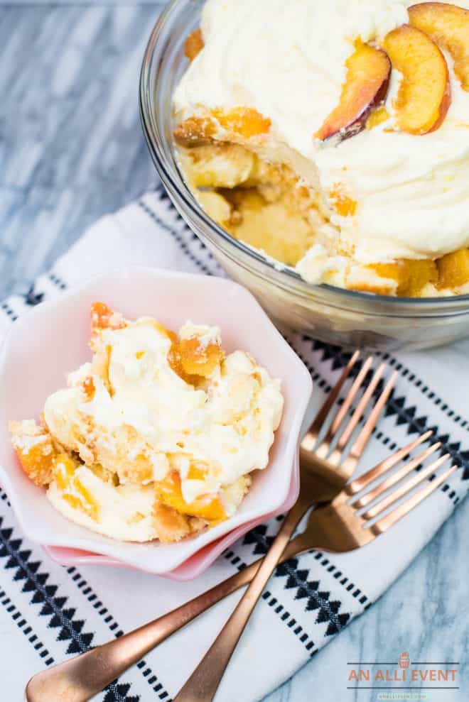 Peaches and Cream Trifle served in a fluted pink bowl with rose gold forks