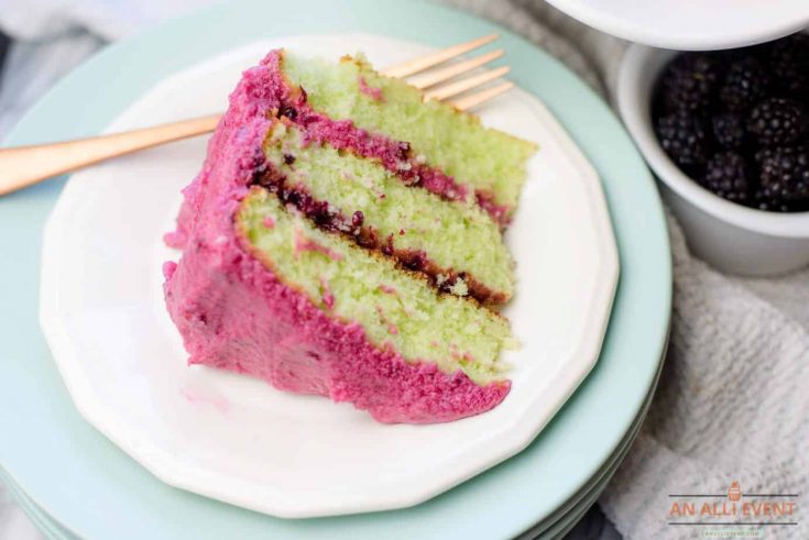 Slice of 3-layer blackberry lime cake with blackberry coulis and blackberry buttercream