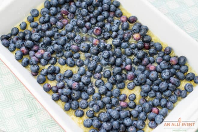 Fresh blueberries layered over crushed pineapple in 9x13 pan