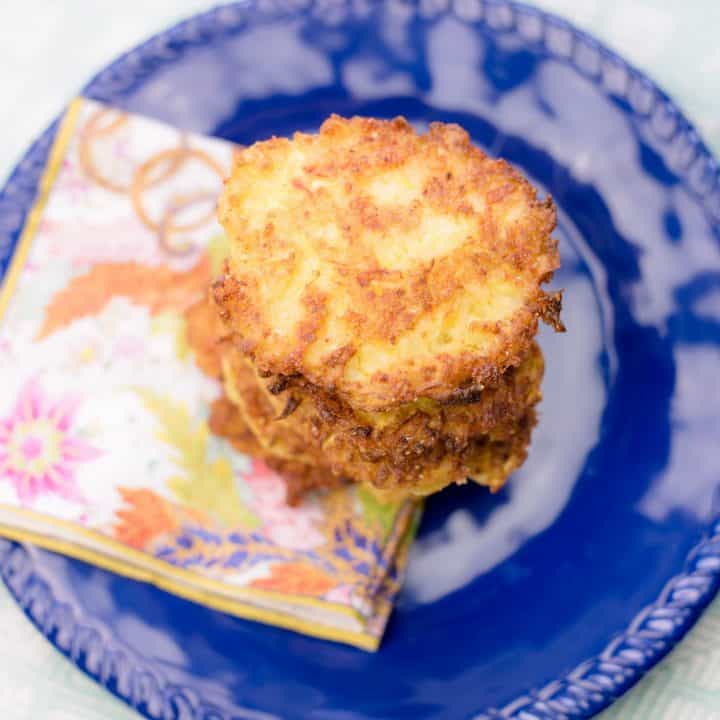 Squash patties stacked on a navy blue plate