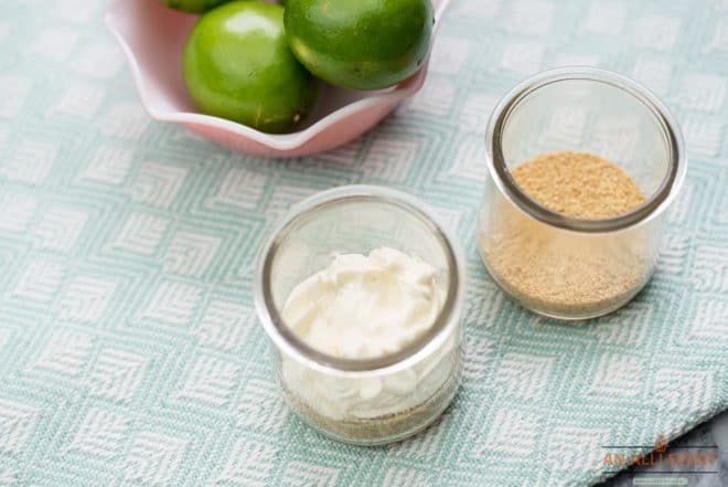 Layers of graham crackers and lime cheesecake pudding in small glass jar