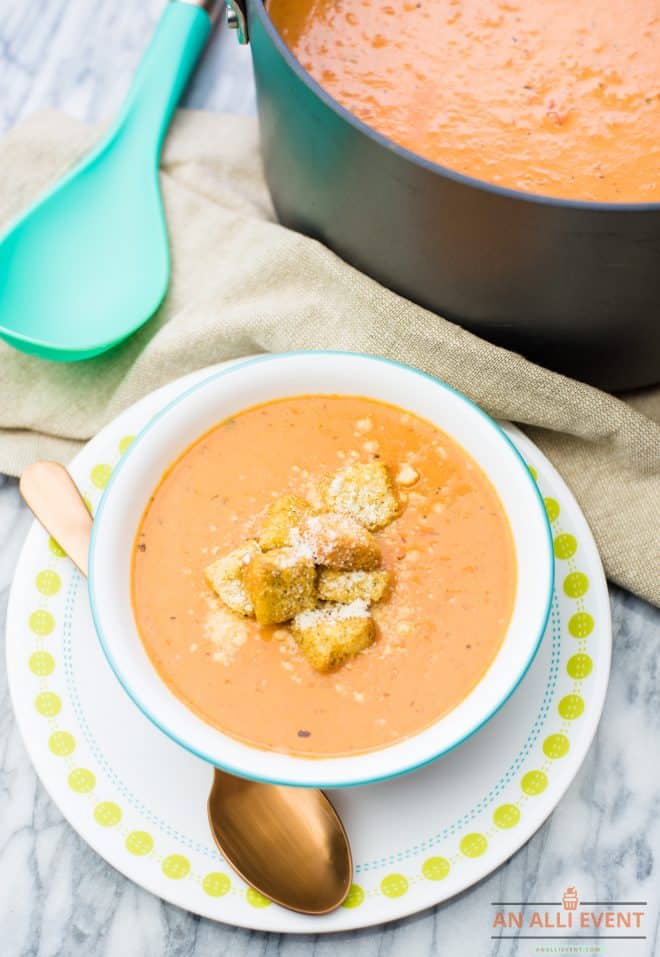 Tomato Soup topped with croutons and cheese, served in a white bowl