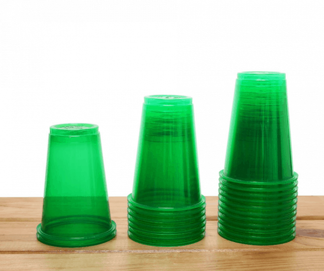 Green Plastic Cups stacked on brown stained table - Fun Family Christmas Games