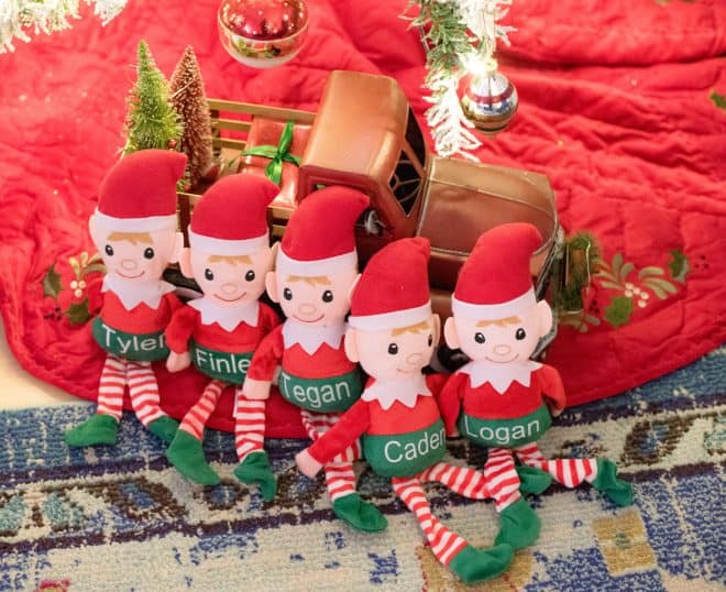 Elf dolls under the Christmas Tree in front of a red truck