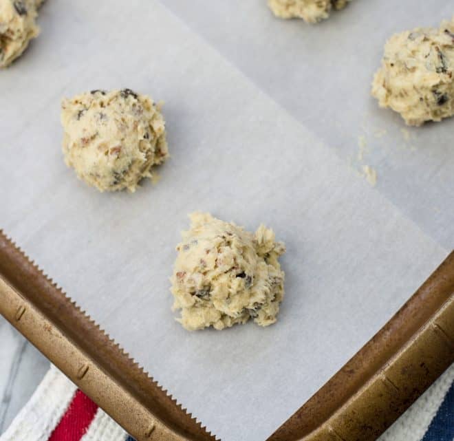 Cookie Dough scooped onto parchment paper lined baking sheet