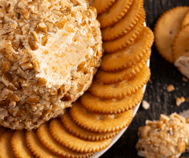 cheeseball on white platter with crackers