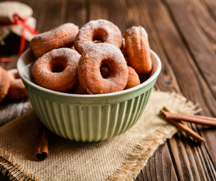 Doughnuts in green bowl on wood table