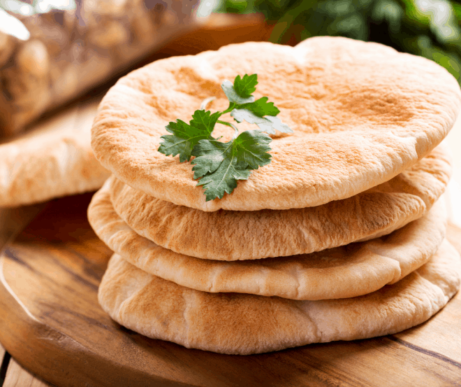 rounds of toasted pita bread rounds on a cutting board