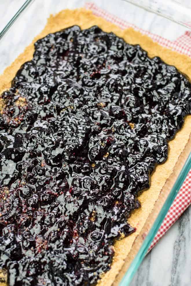 Blueberry Preserves spread evenly over a graham cracker crust