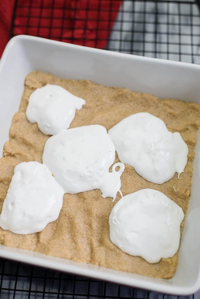 Spoonfuls of marshmallow creme on graham cracker crust