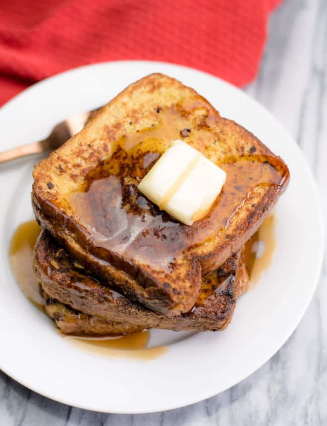 Stuffed French Toast on a white plate with a pat of butter and syrup