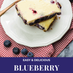 Blueberry Cheesecake Bars stacked on a small white plate