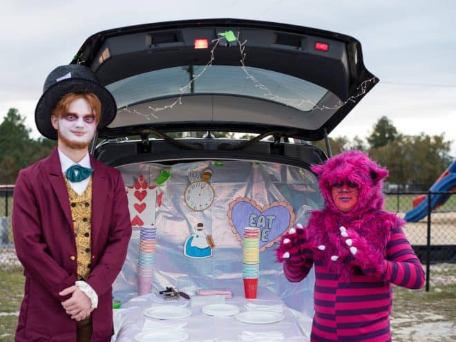 The Mad Hatter in front of a trunk decorated for Trunk or Treat