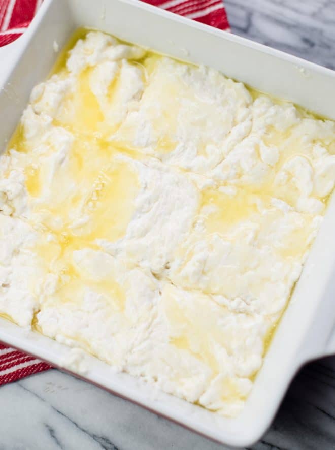 Biscuit dough in square baking pan ready to be baked