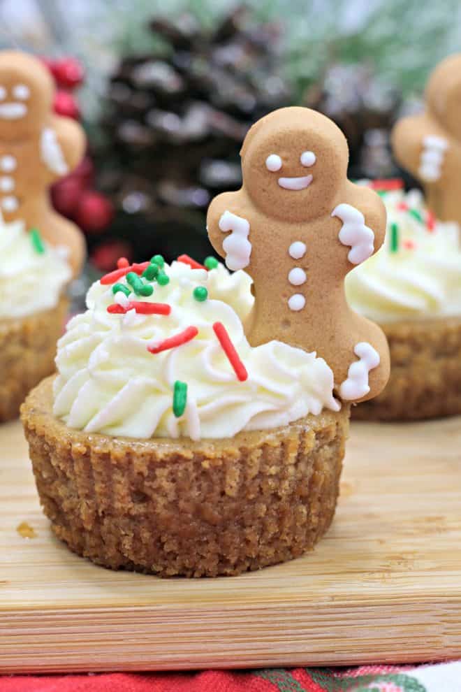 gingerbread cupcakes topped with whipped cream and a mini gingerbread man