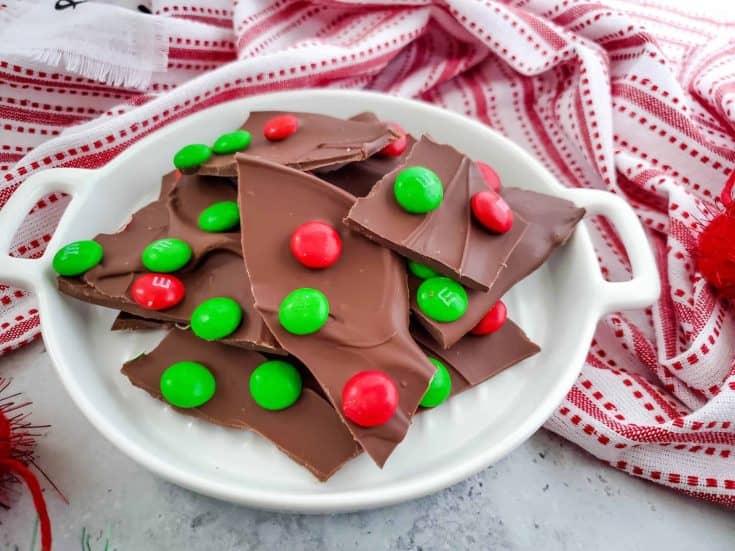 Easy Chocolate Bark With Red and Green M&Ms on a white serving platter with handles