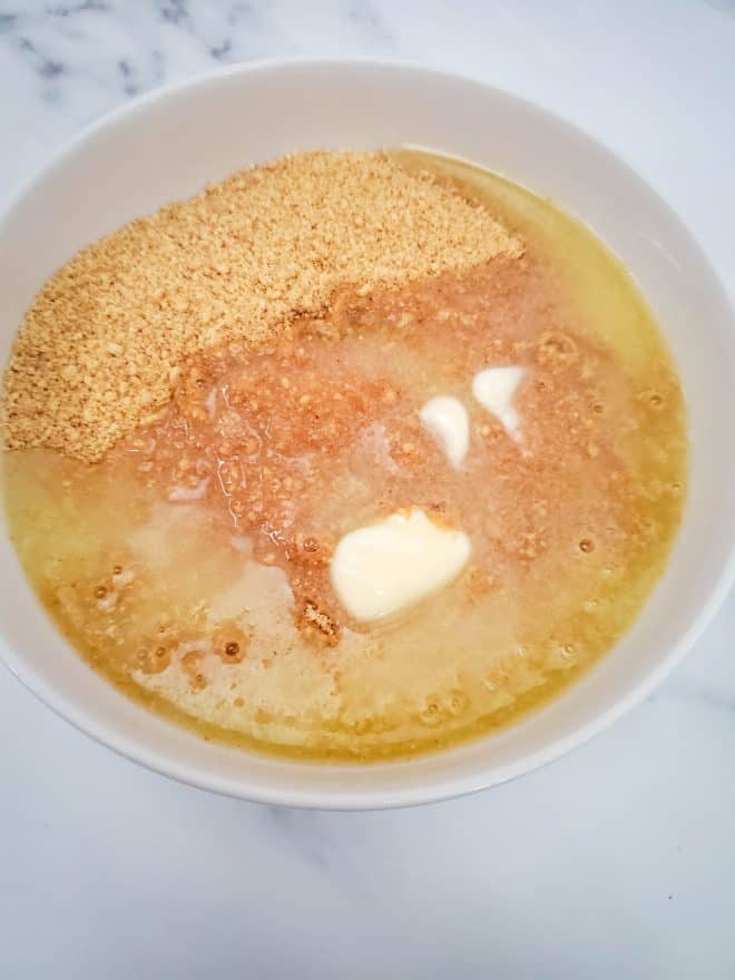 graham cracker crumbs and butter in a bowl