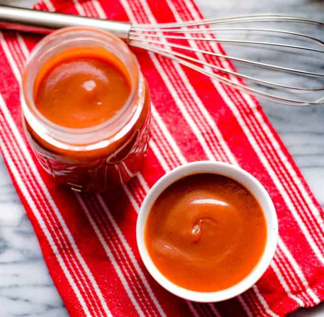 Coca-Cola Barbecue Sauce in a jar on a red and white stripped dishcloth