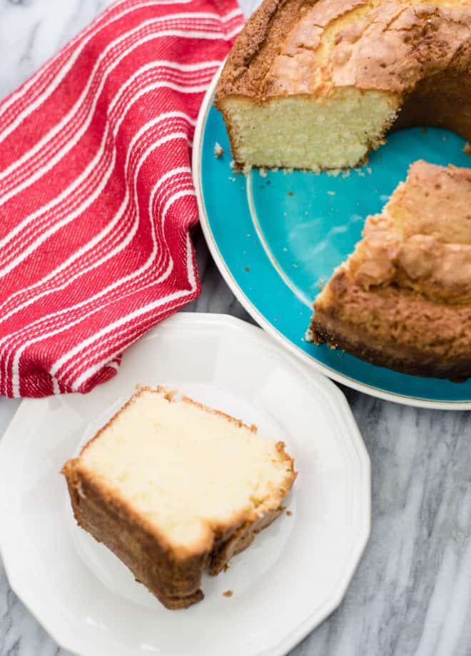 Coconut Pound Cake on blue plate with one slice in front on a dessert plate