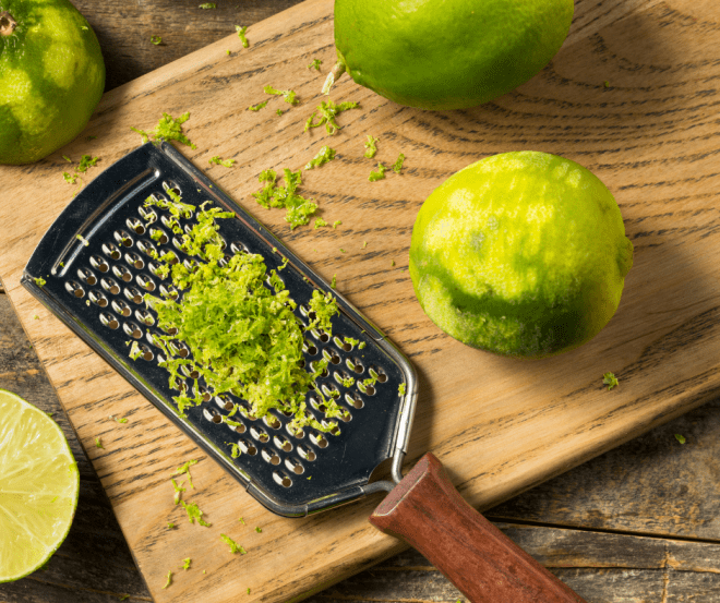 lime zest and microplane on wooden cutting board